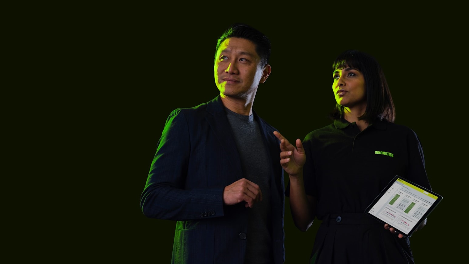 A man and a woman talking about something. The woman is holding a tablet with the Inspire IQ app- A man and a woman talking about something. The woman is holding a tablet with the Inspire IQ app-